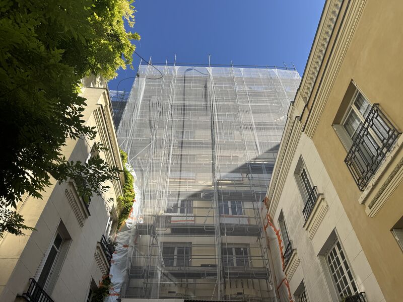 Façade d’immeuble sous échafaudage dans une cour