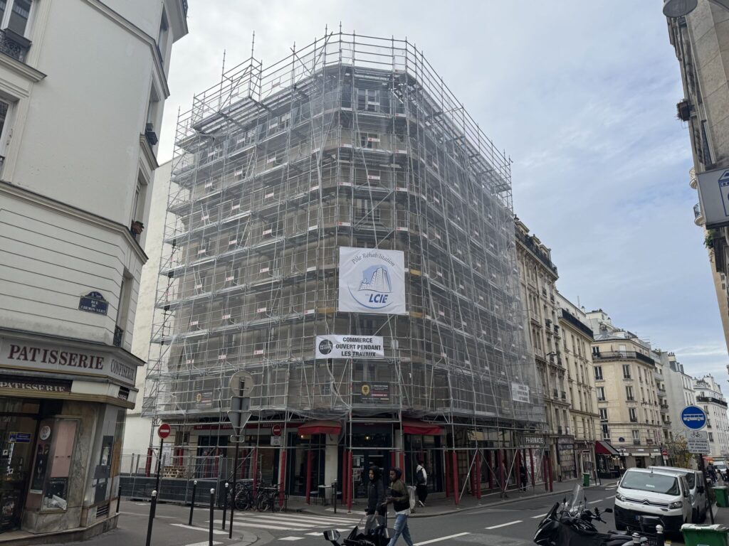 Immeuble du Chemin-Vert, Paris 11e, sous échafaudage avec la bâche LCIE, commerces ouverts pendant les travaux